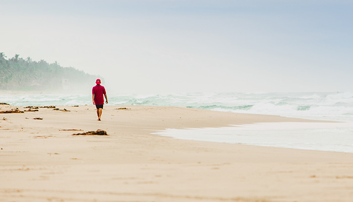 A man taking a walk on the beach