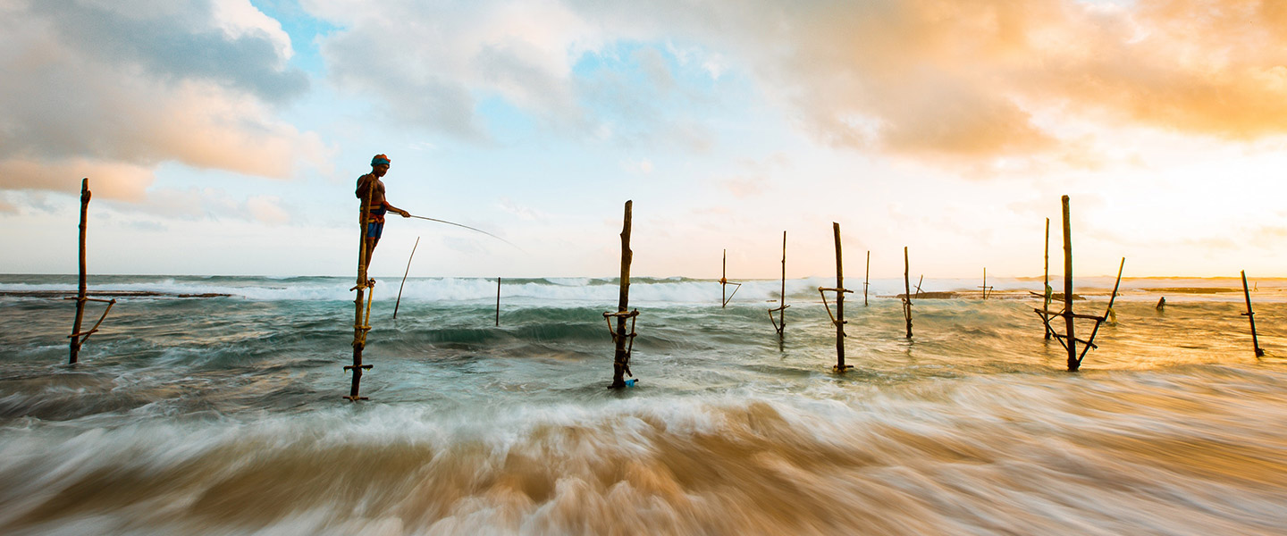 Fishermen on stilts harvesting fish