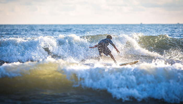 A child attempting to surf in the sea