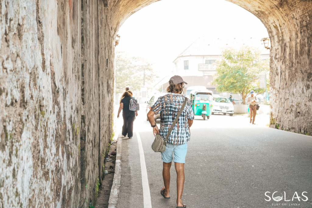 Young man walking through the entrance walls of Galle Fort, Sri Lanka